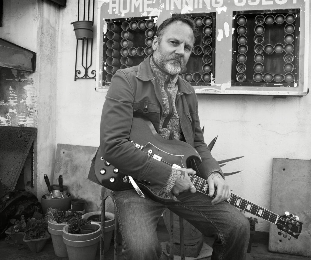 Matt Clark seated with Gibson SG guitar